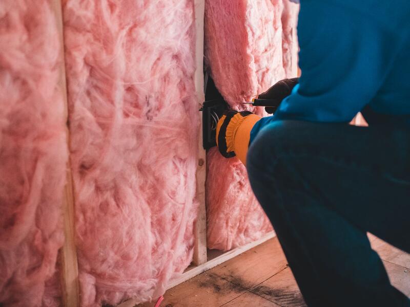 Pose d’un isolant thermique sur la paroi d’un logement en rénovation.